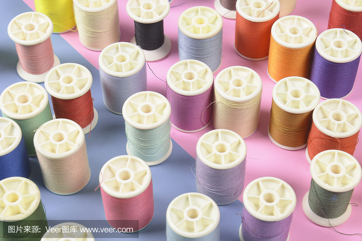 平铺的彩色线卷,用于缝制两种色调的背景,缝纫和刺绣的概念。